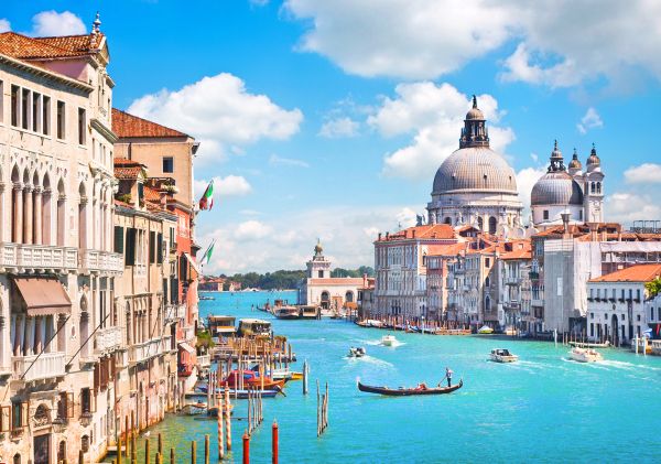 Sembrava davvero Venezia: l'acqua verde e calma che rifletteva i palazzi antichi, i ponti di pietra che si arcuavano eleganti sopra i canali, le facciate color pastello consumate dal tempo e quel profumo salmastro che si mescolava all'odore di leg...