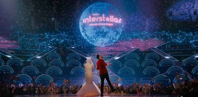 In alto, sopra al palco dove molto probabilmente si sarebbe presto esibita la madre — visto che erano lì per lei — fluttuava un globo olografico con la scritta "Interstellar Contest" in rosa che gli orbitava attorno